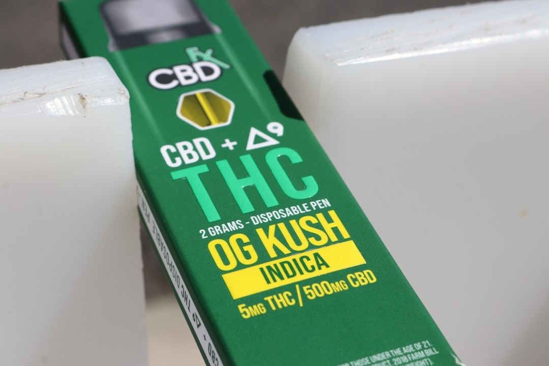 Green CBD + Delta-9 THC vape pen box between off-white blocks.
